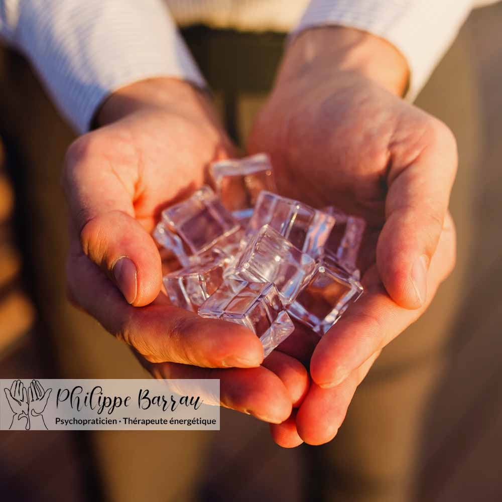 Mains tenant des cubes de glace, illustration symbolique de l’apaisement dans la pratique du coupeur de feu.